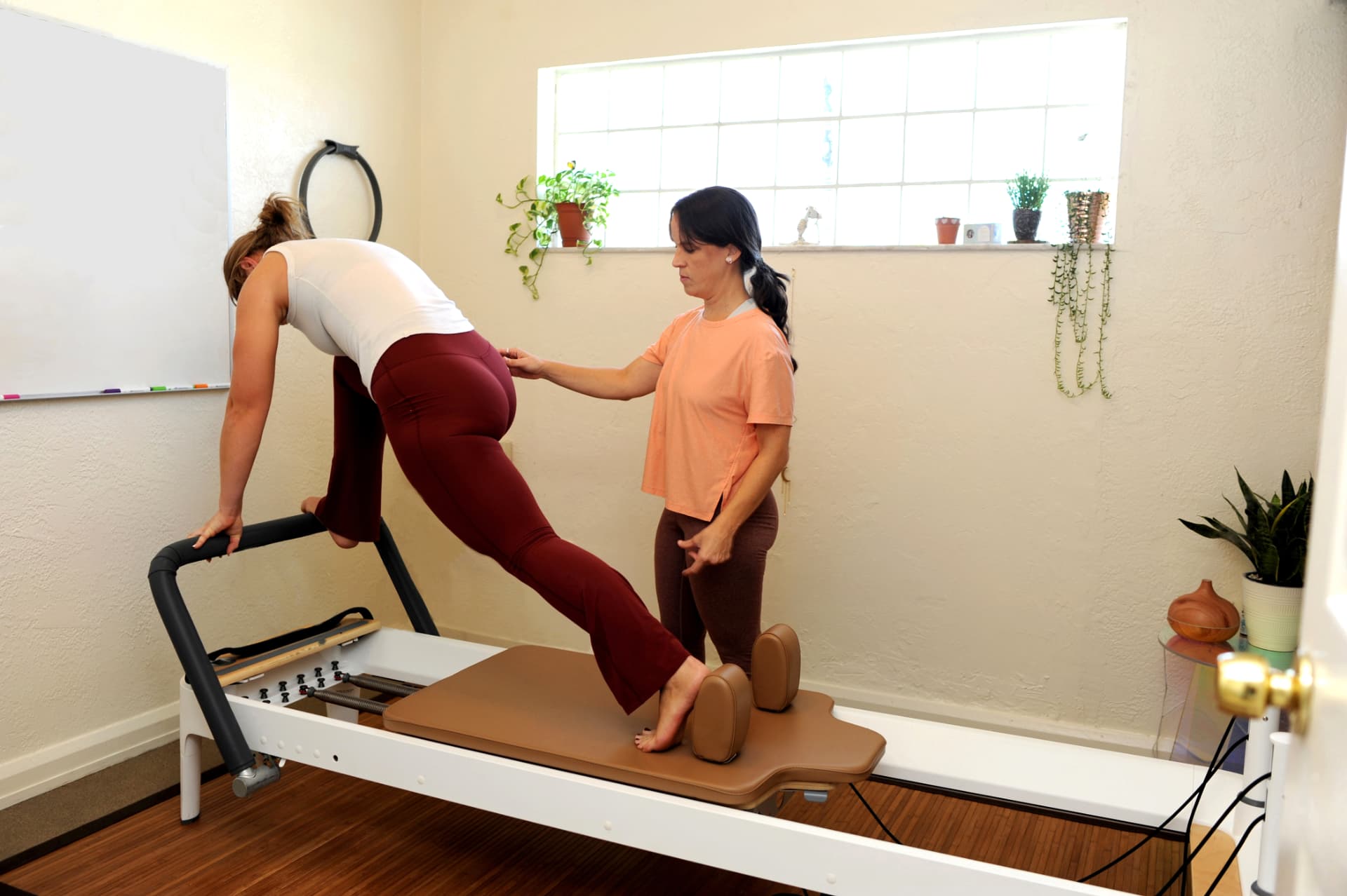 Ivonne supporting a client's leg work on the reformer
